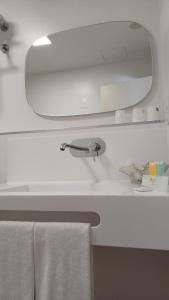 拉瓦克拉圣雅各之路酒店的浴室水槽配有镜子和毛巾