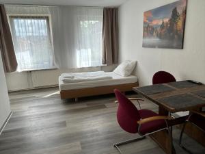 汉诺威Othman Appartements Pfarrstraße 54 2OG的配有一张床和一张桌子及椅子的房间