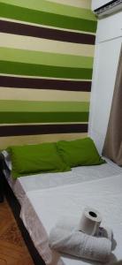 科隆Ofiuras Hostal的一张带绿色和白色条纹墙的床