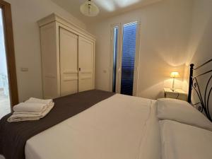 托里德欧索Villetta da Carmen的一间白色卧室,房间内设有一张大床