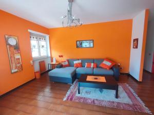 奥斯塔La Betulla Appartamento confortevole Wifi e Parking free的客厅设有蓝色的沙发和橙色的墙壁