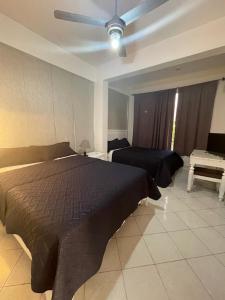 博卡奇卡Hotel Costa Linda Beach Boca Chica的一间卧室配有一张床和吊扇