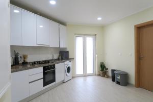 里斯本Lisbon Key Hub - Rooms 1-5的厨房配有白色橱柜、洗衣机和烘干机