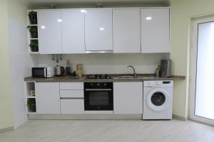 里斯本Lisbon Key Hub - Rooms 1-5的厨房配有白色橱柜和洗衣机。
