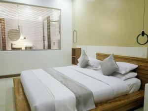 坎帕拉Isabirye residence的卧室配有一张带白色床单和枕头的大床。