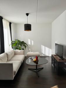 马尔默Tranquil and Convenience Southern Malmo Apartment的客厅配有白色的沙发和桌子
