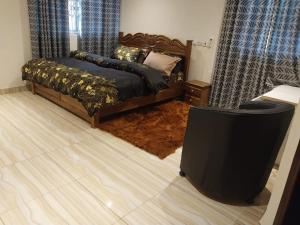 库马西EuChris Homes的一间卧室配有一张床和一台平面电视