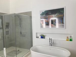 安东尼奥港吉加姆酒店的一间带玻璃淋浴和水槽的浴室