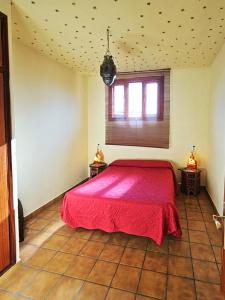 瓜迪亚纳河畔桑卢卡尔Casas Rurales Los Molinos的一间在房间内配有红色床的卧室