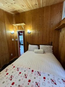 莫兰高地Chalet Alpin Suisse Au Bord Du Lac的卧室配有木墙内的一张床