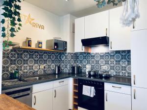 德累斯顿STARiVA - modernes Terrassen Apartment - Duplex Garage - Netflix的厨房的墙壁上铺有黑白瓷砖。