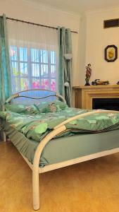 阿莫拉Dream home的卧室内的一张带绿色棉被的床
