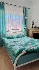 阿莫拉Dream home的一张带绿棉被的床,上面有娃娃