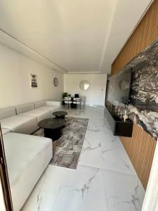 马拉喀什Appartement Prestigia 3 chambres的客厅设有白色沙发和大理石地板。