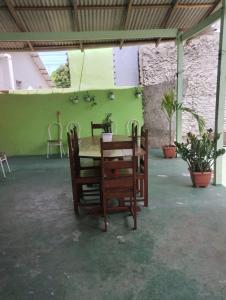 帕林廷斯Casa em Parintins的绿墙客房内的桌椅