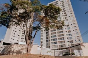 阿拉沙Apartamentos de Temporada Araxá WIFI GRATUITO - ESPAÇO HOME OFFICE的一座高楼前的树