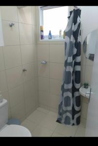 瓜拉廷格塔Nosso canto的带淋浴帘和卫生间的浴室