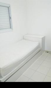 瓜拉廷格塔Nosso canto的白色的窗户客房内的一张白色的床
