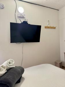 圣安德烈斯Luky's Rooms的卧室配有一张床和壁挂式平面电视。