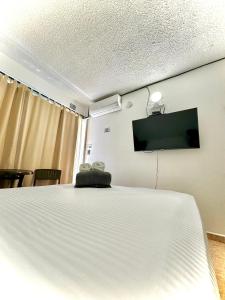 圣安德烈斯Luky's Rooms的客房设有一张床和一台平面电视。