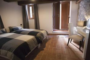 Schiavi di Abruzzo阿里吉利住宿加早餐旅馆的一间卧室设有两张床、一张桌子和一个窗口。