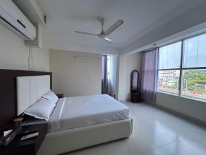 巴里沙尔Hotel Kingfisher - Barishal的一间卧室配有一张床和吊扇