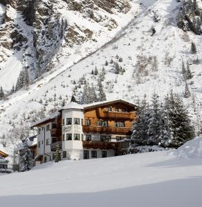 皮茨河谷圣莱昂哈德阿尔霍夫雷特夫匹兹塔尔旅馆的山前雪中建筑物