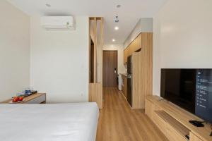 河内22Housing Luxury Apartment 81 Linh Lang的一间卧室配有一张床和一台平面电视