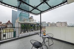 河内22Housing Luxury Apartment 81 Linh Lang的大楼内的阳台配有桌椅