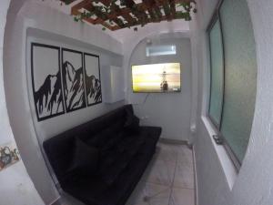 麦德林Right in the heart of Medellin的客厅配有黑色沙发和窗户
