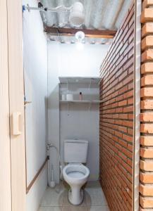 乌贝兰迪亚Quarto 04 Pousada Roosevelt的一间带卫生间和砖墙的浴室