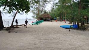 丹戎槟榔Madu Tiga Beach and Resort的两人在带游乐场的海滩上散步