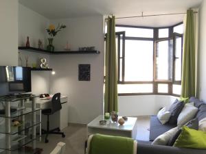 大加那利岛拉斯帕尔马斯迈伊公寓的客厅配有沙发、桌子和书桌