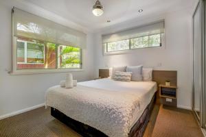 楠巴卡黑兹BIG4 Tasman Holiday Parks - Nambucca Heads的一间卧室设有一张大床和两个窗户。