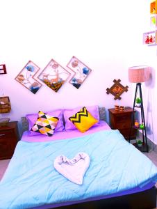 焦尔哈德JDreamland Homestay的卧室配有一张蓝色的床,墙上挂有图片