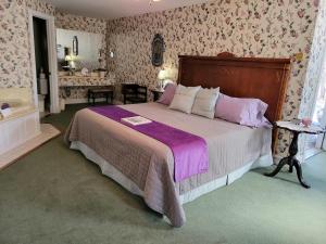 尤里卡斯普林斯Evening Shade Inn的一间卧室配有一张带紫色床单的大床