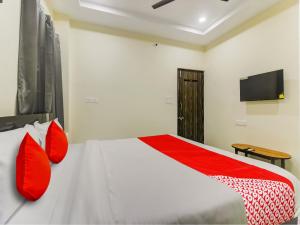 IbrāhīmpatanSRI NIRVANA PRIDE的一间卧室配有一张带红色枕头的床和电视。
