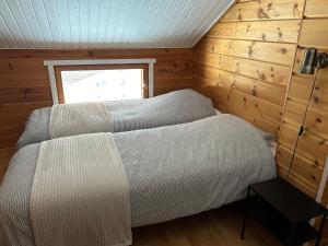 塔库沃里Kodikas loma-asunto Tahkon ytimestä的木制客房内的一间卧室,配有一张床