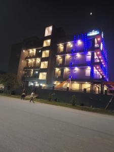 诺伊达Hotel Red York By Byob Hotels的一座晚上有蓝色灯光的建筑