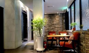 昌原市Jinhae Pasta Hotel的配有桌椅和砖墙的房间