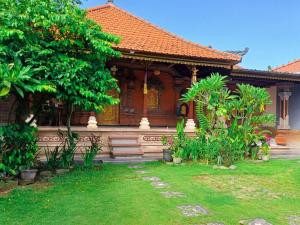 KrambitanRumah Bali Kelating的前面有花园的房子