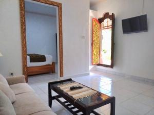 KrambitanRumah Bali Kelating的带沙发、桌子和镜子的客厅