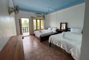 万荣Blue Sunset Hostel的酒店客房设有两张床和窗户。