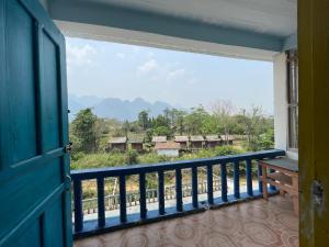 万荣Blue Sunset Hostel的设有一个窗户的阳台,享有村庄的景色