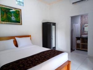 KrambitanRumah Bali Kelating的一间带白色床的卧室和一间浴室