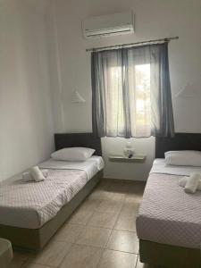 佩里萨马洛熙酒店的一间卧室设有两张床和窗户。