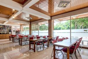 日惹Collection O 93742 Sidodadi Hotel Dan Resto的用餐室设有桌椅和窗户。