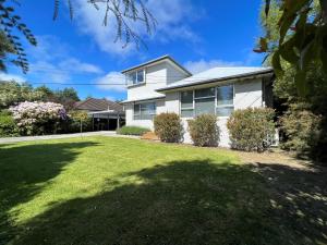 基督城Charlesworth Villa - Christchurch Holiday Homes的前面有大院子的房子