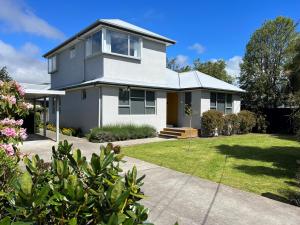 基督城Charlesworth Villa - Christchurch Holiday Homes的一座带庭院的大型白色房屋