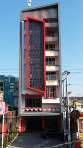 SeturanHotel Brothers Inn Babarsari的一座高大的建筑,上面有红色的长方形